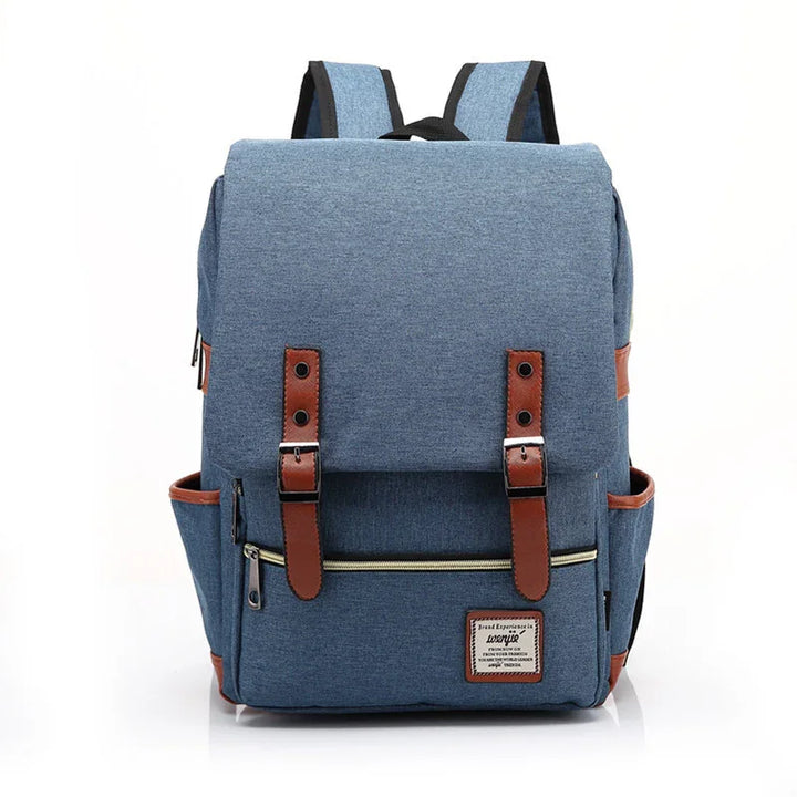 Blue canvas backpack with brown leather straps, front zipper pocket, and side pockets