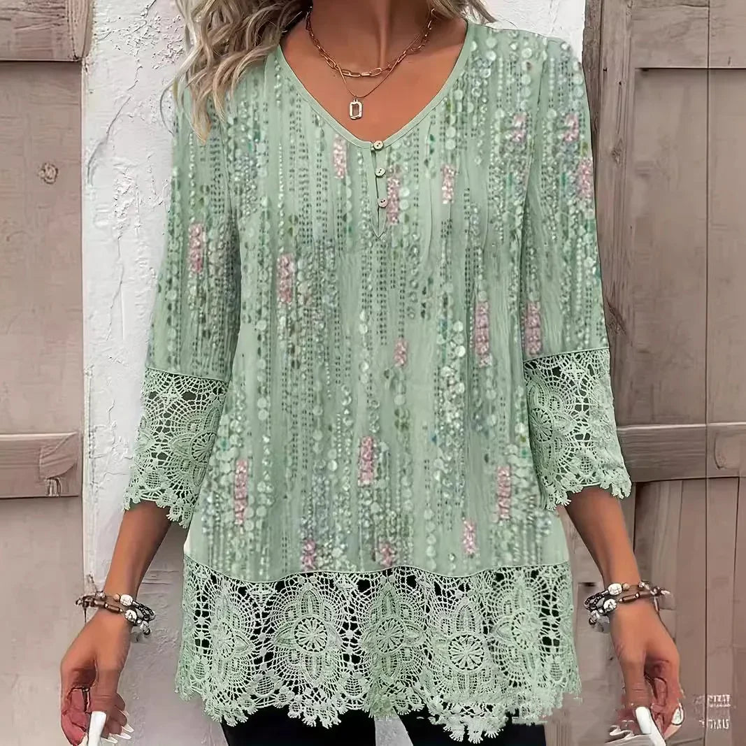 Woman wearing mint green patterned blouse with lace sleeves and hem, layered gold necklaces, and bracelets