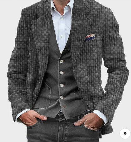 Man wearing textured grey blazer and dark buttoned waistcoat over white shirt with hands in pockets