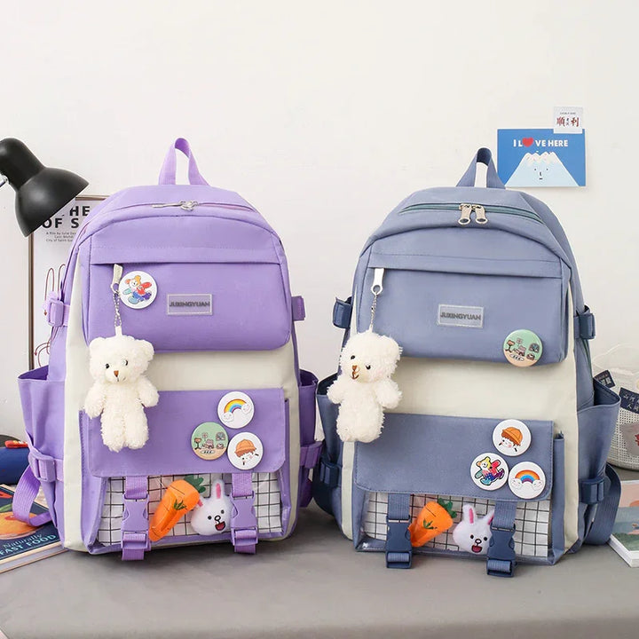 Two colorful backpacks in purple and blue with teddy bear keychains, pins, and cute stuffed toys