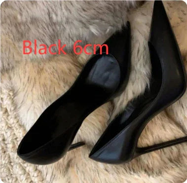 Black 6cm high heel shoes with pointed toes on a furry rug