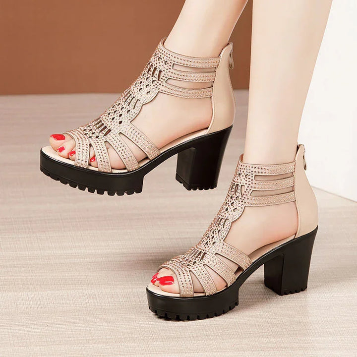 Beige high-heeled gladiator sandals with studded cut-out design and black chunky platform soles