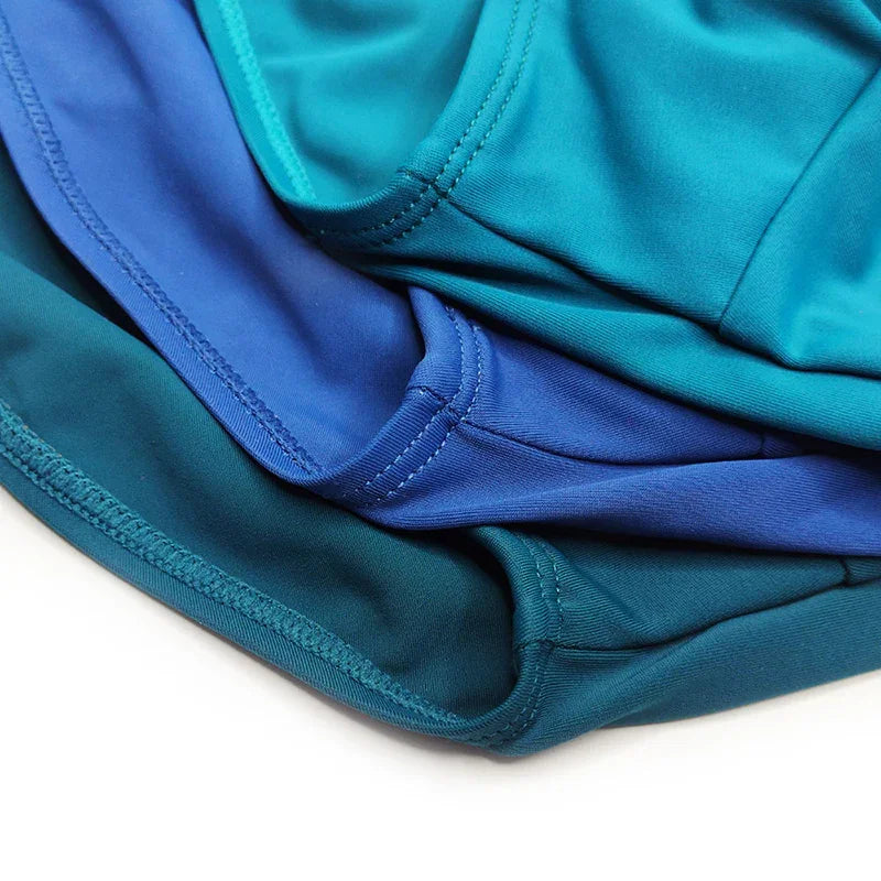 Close-up of folded multicolored sportswear fabric in blue and teal with detailed stitching