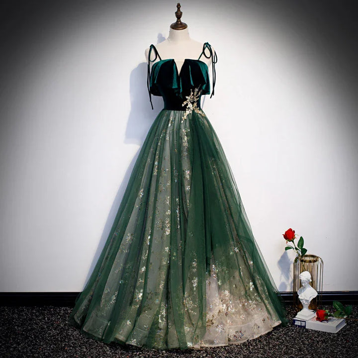 Elegant dark green velvet evening gown with floral embroidery and tulle skirt on mannequin