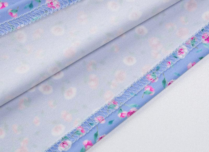 Close-up of light blue fabric with pink floral print and visible overlock stitch detailing