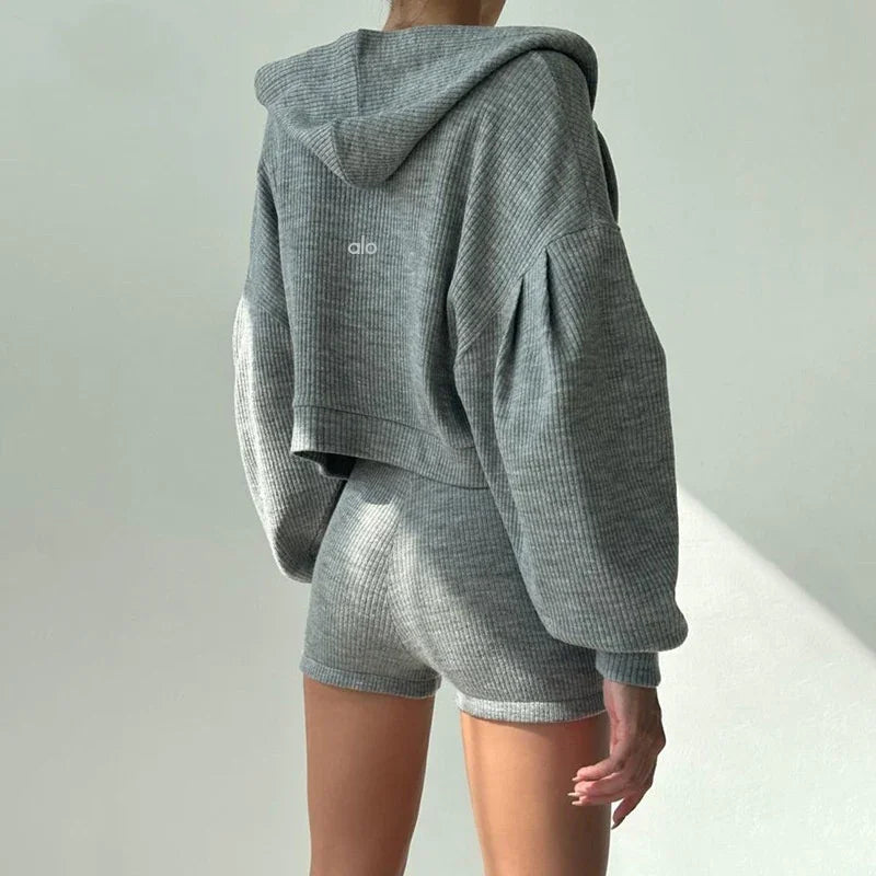Back view of a person wearing grey ribbed hoodie and matching shorts in soft texture