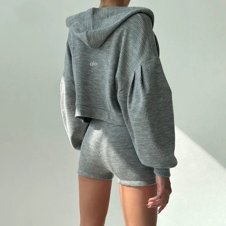 Back view of a person wearing grey ribbed hoodie and matching shorts in soft texture