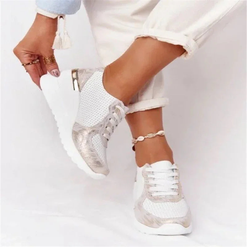 White and silver perforated sneakers worn with rolled-up white pants and a shell anklet