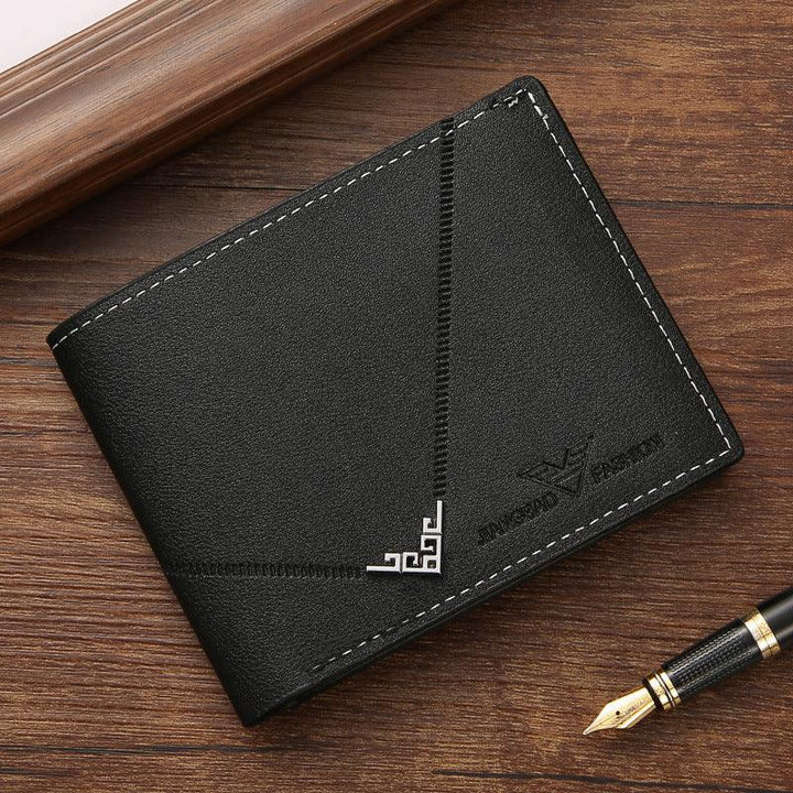 Black leather men's wallet with white stitching and embossed brand logo on wooden surface