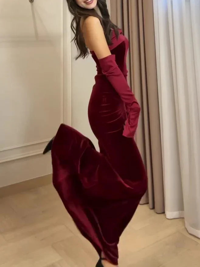 Woman twirling in a red velvet strapless gown with matching gloves in an elegant room