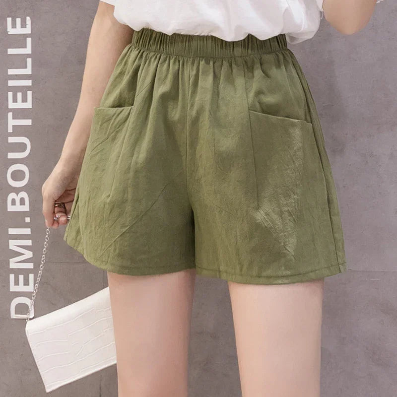 Woman wearing casual olive green elastic waist shorts with front pockets and white top