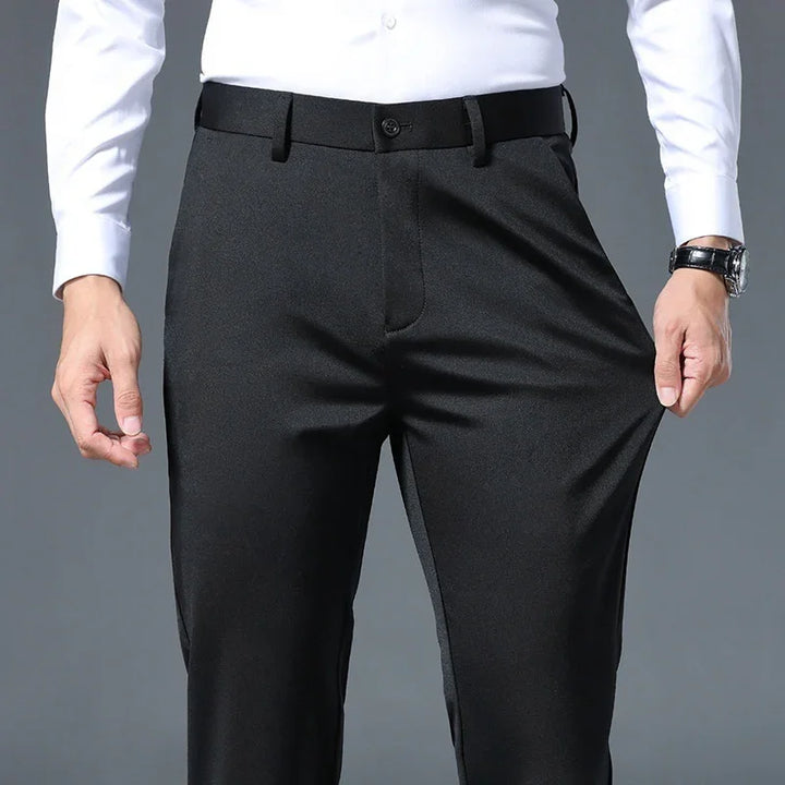 Man wearing black stretch formal pants with white shirt, showing flexibility of fabric