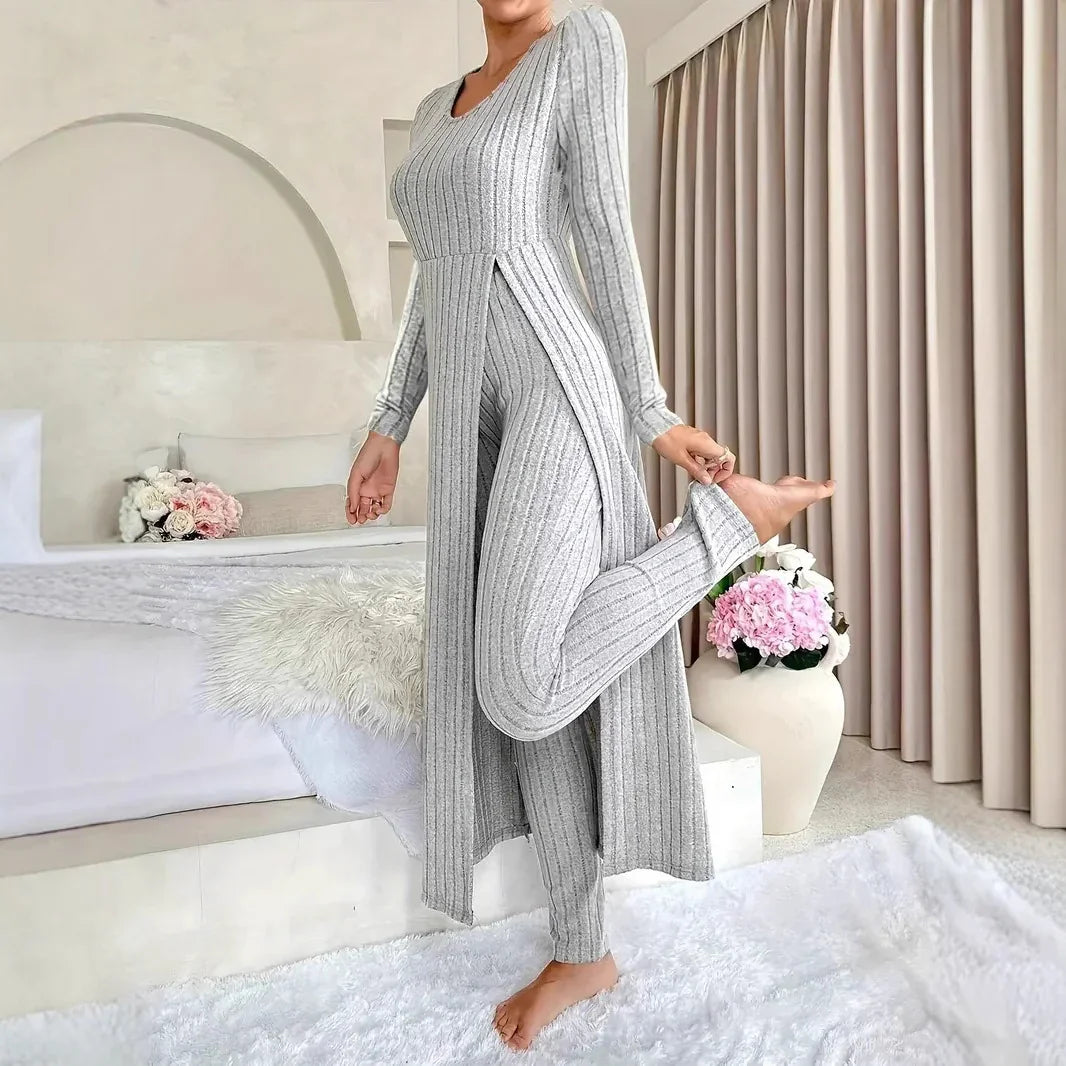 Woman wearing gray ribbed knit loungewear set posing barefoot in modern cozy bedroom