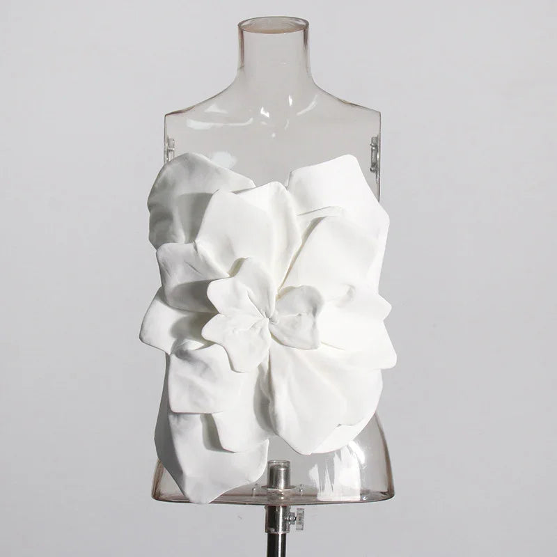 White sculptural flower top displayed on clear mannequin against plain background
