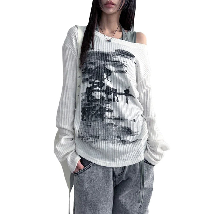 Woman wearing oversized white ribbed graphic sweater with black print and gray loose jeans