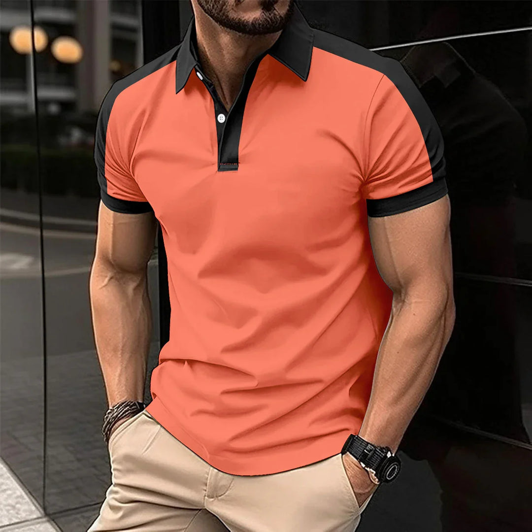 Man wearing a slim fit orange polo shirt with black collar and sleeve trim standing outdoors