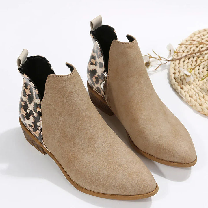 Pair of tan suede ankle boots with leopard print back panels and low wooden heels on white background