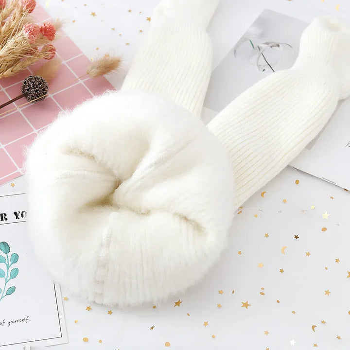 Soft white fleece-lined winter leggings on decorative background with dried flowers