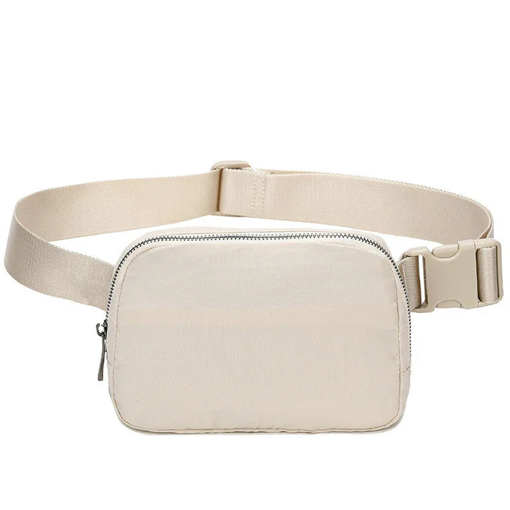 Beige nylon waist bag with adjustable strap and zipper closure on white background