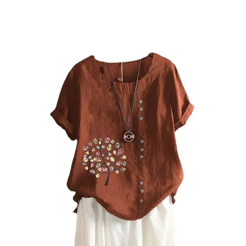 Brown short-sleeve blouse with button details and colorful tree print, paired with white pants
