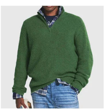 Man wearing green knit pullover sweater over blue plaid shirt with blue jeans