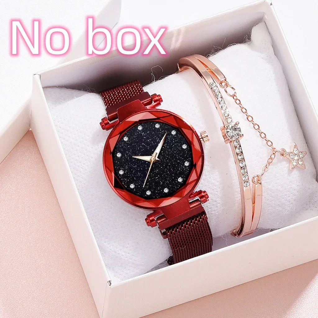 red wristwatch with glittery black face and crystal markers next to rose gold bracelet with charm in white gift box