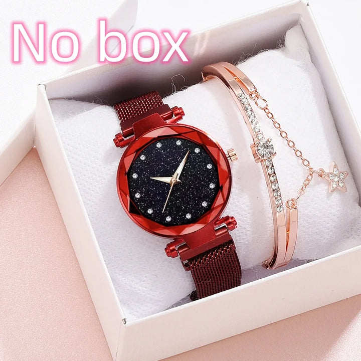 red wristwatch with glittery black face and crystal markers next to rose gold bracelet with charm in white gift box