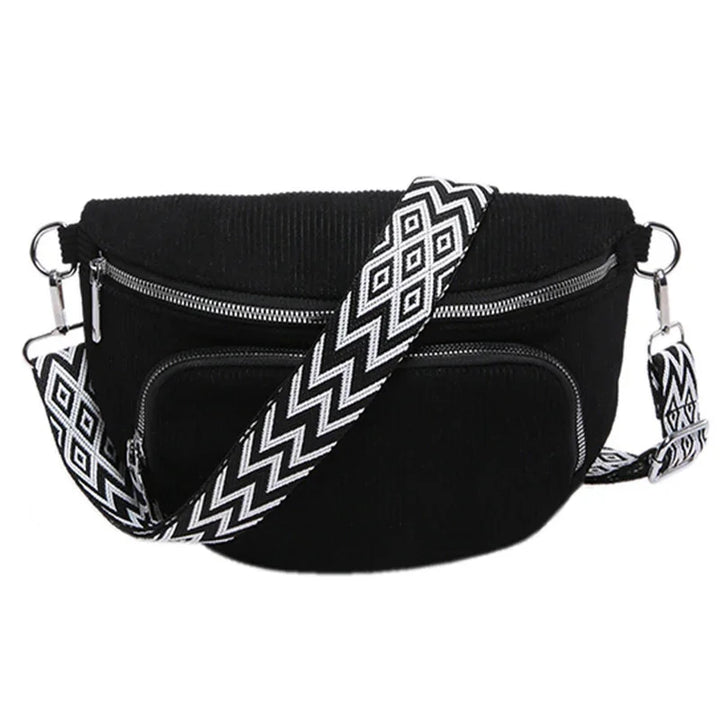 Black crossbody bag with front zipper pocket and detachable black and white patterned strap