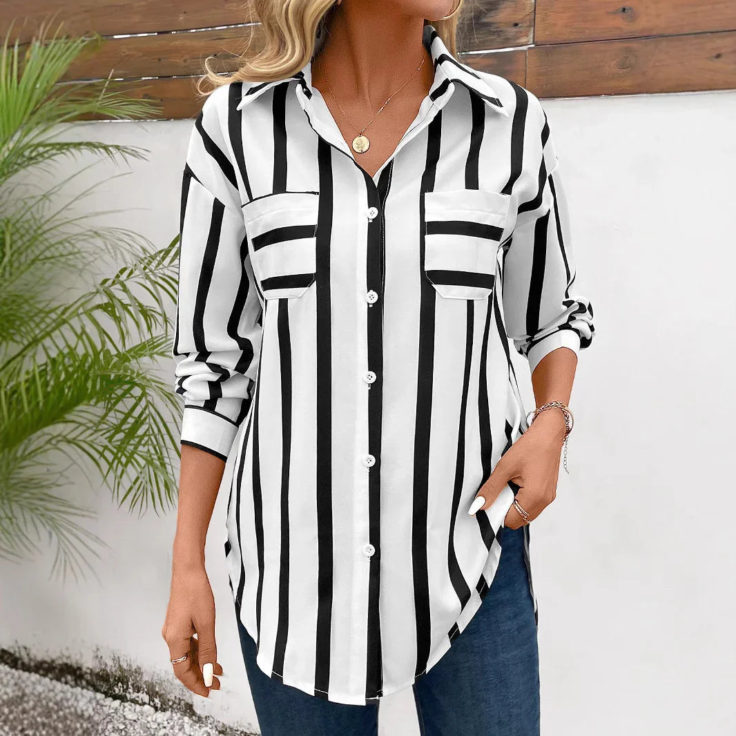 Woman wearing black and white vertical striped button-up shirt with rolled sleeves and blue jeans