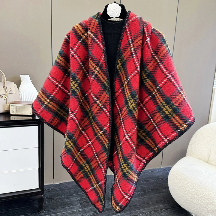 Red plaid wool shawl with black trim displayed on a mannequin in a modern room