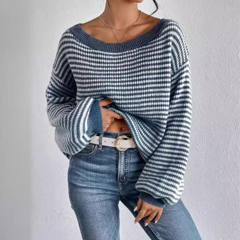 Woman wearing striped blue and white knit sweater with balloon sleeves and blue jeans