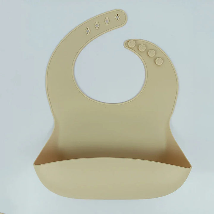 Beige silicone baby bib with adjustable snap buttons and food catcher pocket