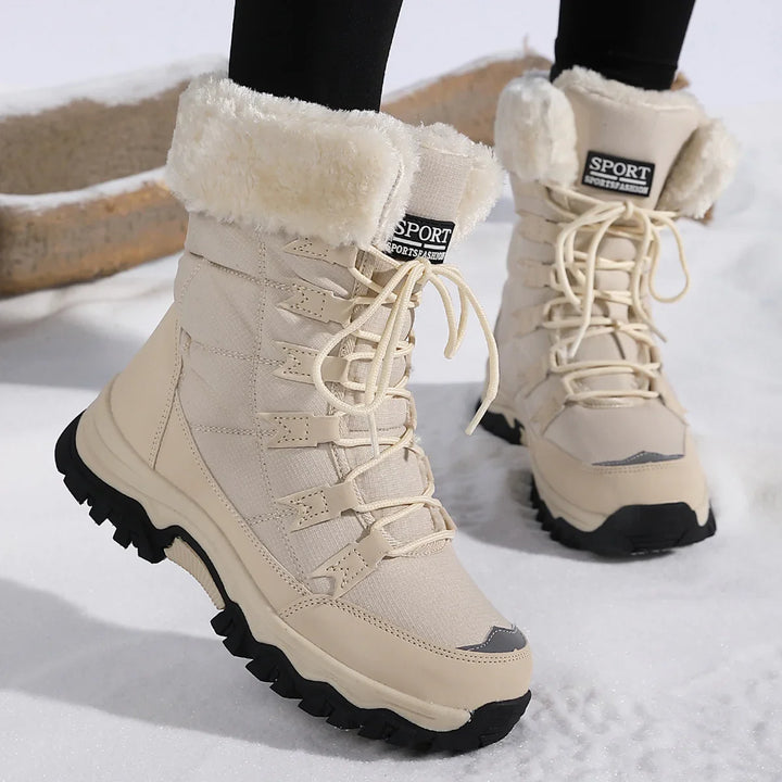 Beige winter boots with black soles and fur lining, worn over black leggings on snow