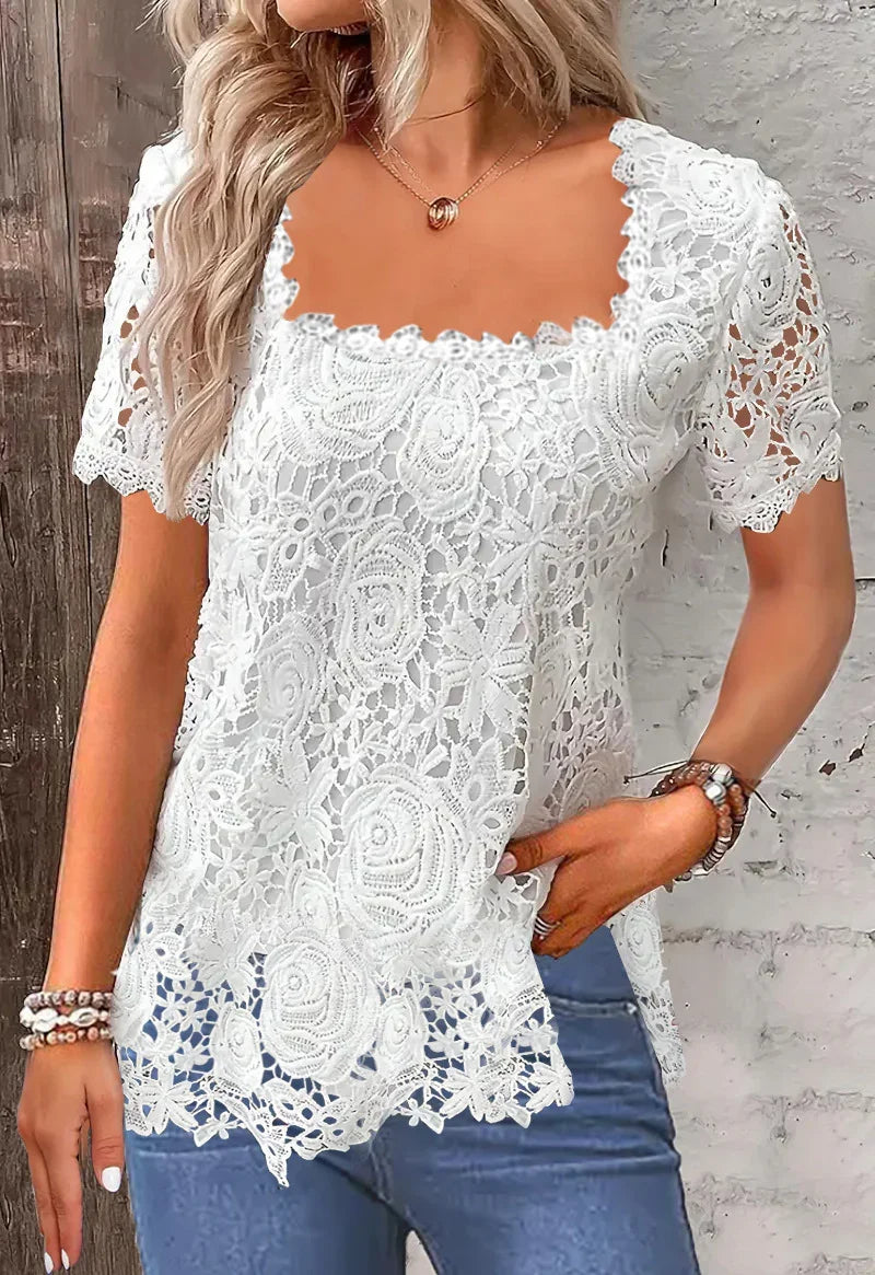 Woman wearing white floral lace short sleeve top paired with blue jeans and beaded bracelets