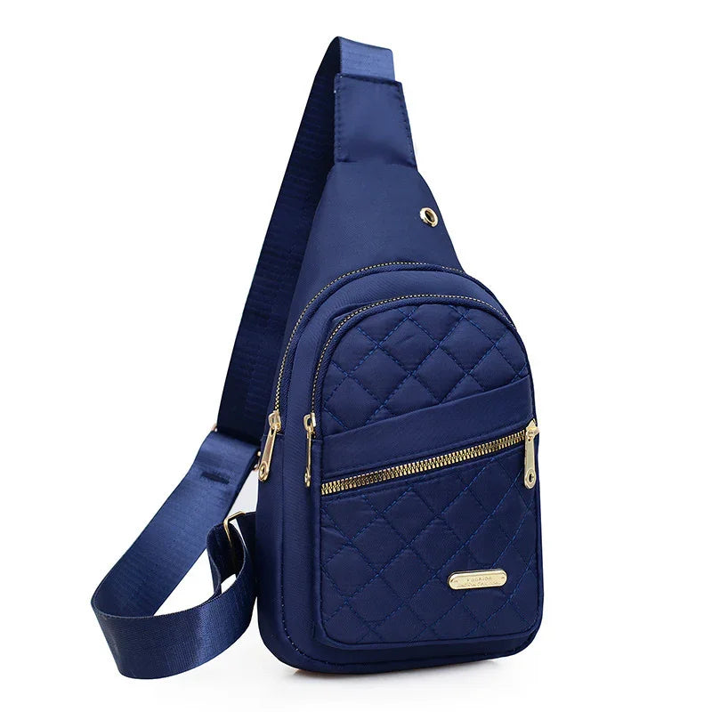 Navy blue quilted crossbody sling bag with gold zippers and adjustable strap