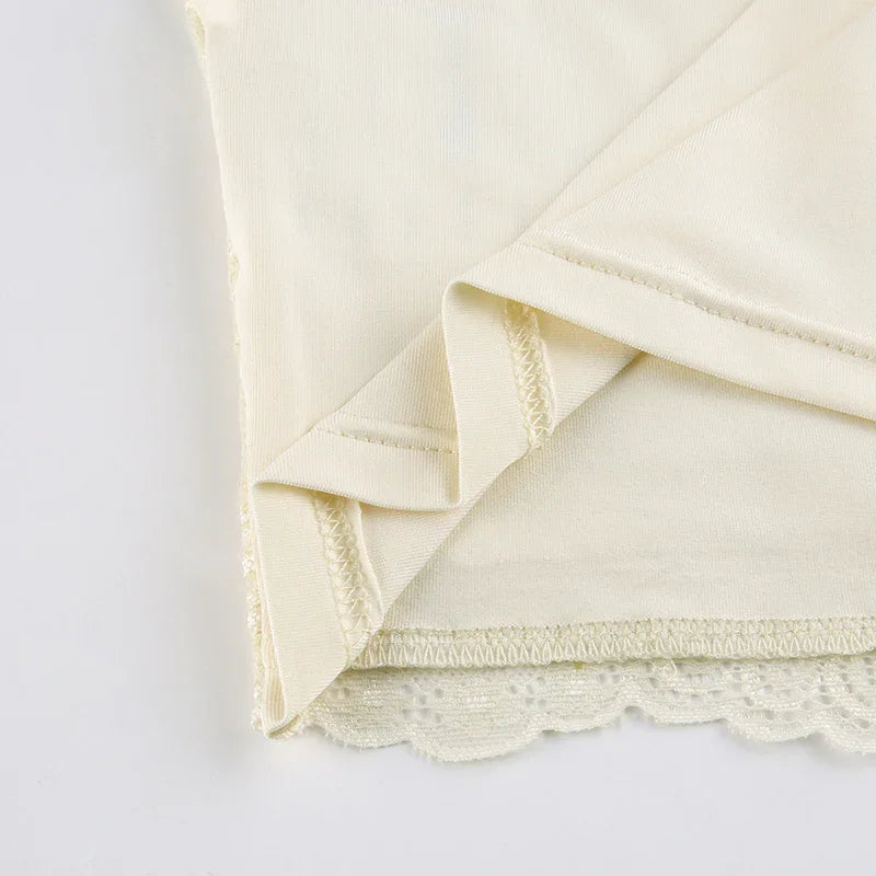Close-up of beige fabric with lace trim and folded hem detail on white background
