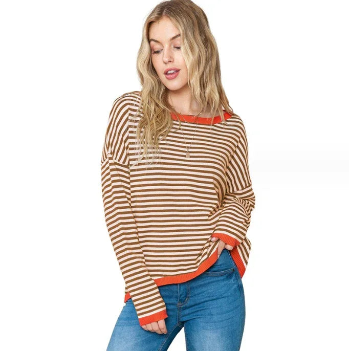 Young woman wearing brown and white striped sweater with orange accents and blue jeans