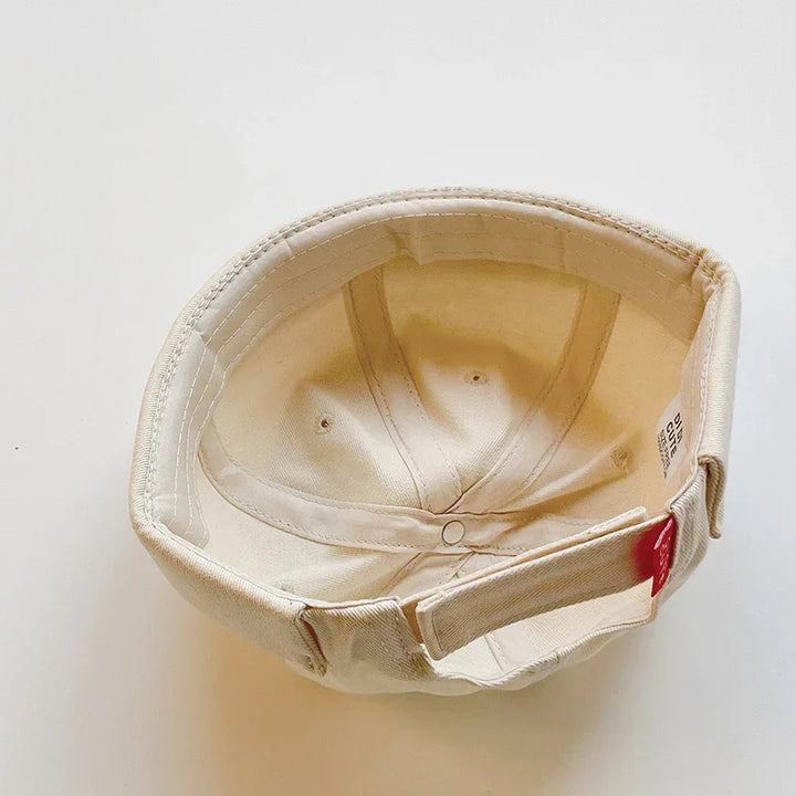 Inside view of a beige cotton cap with adjustable strap on white background