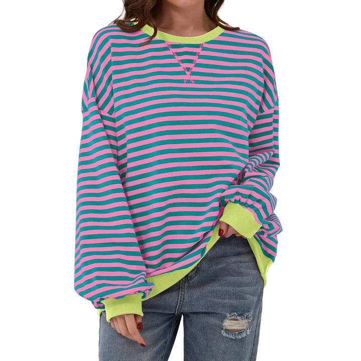 Casual oversized striped sweater with pink and teal stripes, lime green cuffs and neckline, worn with ripped jeans