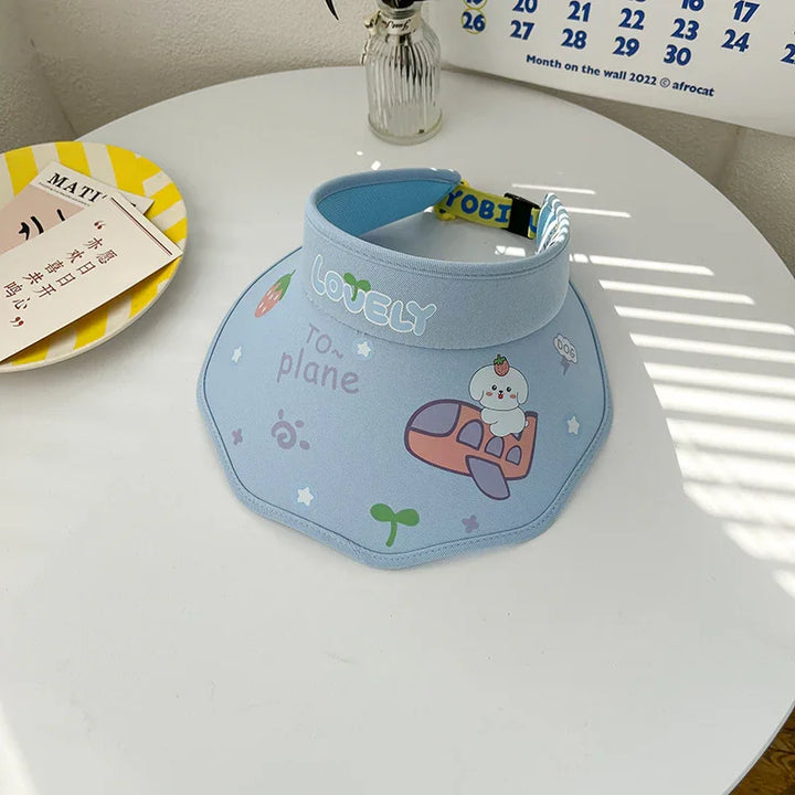 Blue fabric sun visor hat with cute airplane and dog print on white round table