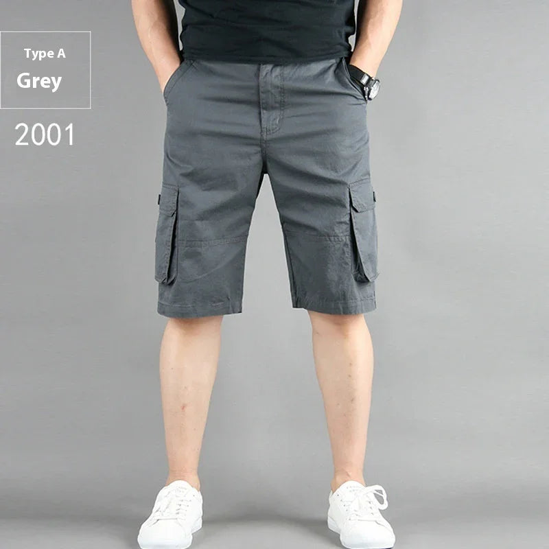 Men's grey cargo shorts with pockets, worn with black shirt and white sneakers on grey background