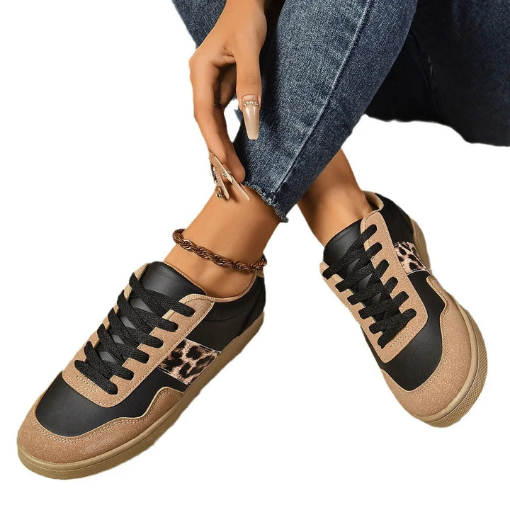 Casual sneakers with black, tan, and leopard print details worn with blue jeans and ankle bracelet