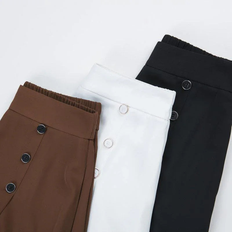 Brown, white, and black high-waisted pants with front buttons on white background