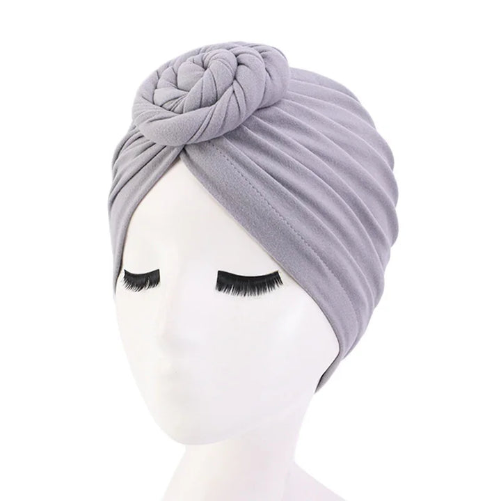Light purple velvet turban headwrap with ruched design and front knot on mannequin head