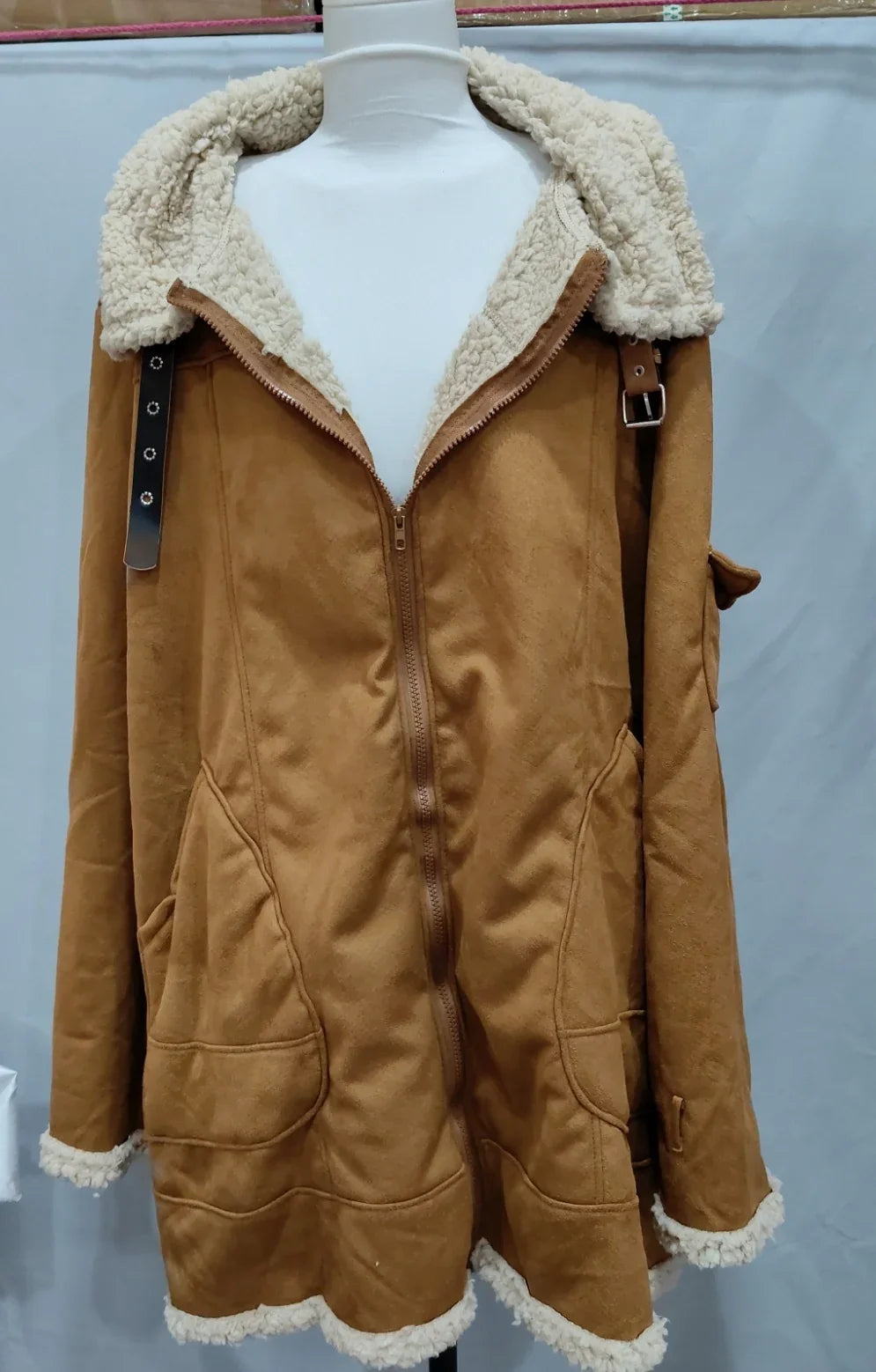 Brown suede jacket with white sherpa lining, front zipper, pockets, and buckle details on sleeves