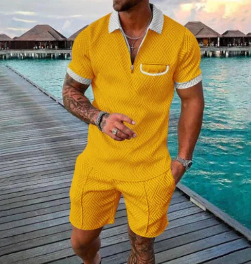 Man wearing bright yellow textured polo shirt and matching shorts standing on wooden pier with overwater bungalows