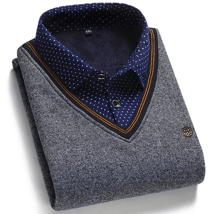 Folded grey V-neck sweater with navy blue and orange trim over a navy blue polka dot collared shirt