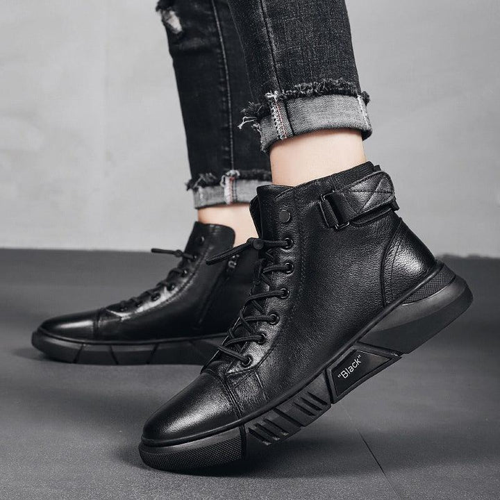 Black leather high-top sneakers with laces and buckle worn with rolled-up distressed black jeans