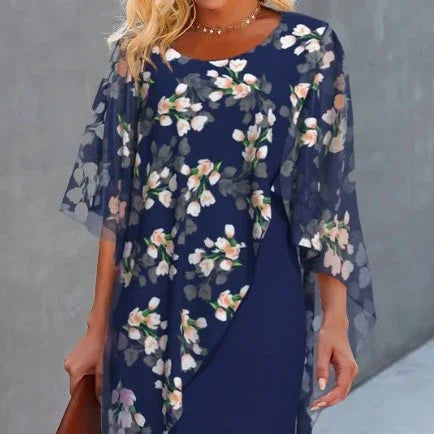 Woman wearing navy blue floral dress with sheer floral overlay and 3/4 sleeves