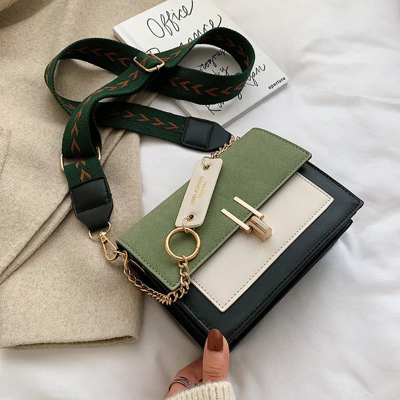 Stylish green, black, and white crossbody bag with gold lock and detachable green strap with brown arrow pattern